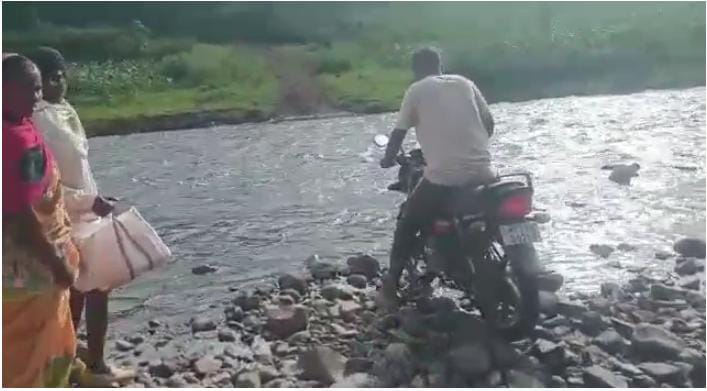जान जोखिम में डालकर नदी पार करते ग्रामीण